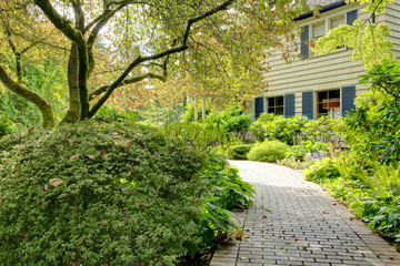 Small American home with light exterior and a large grass filled lawn