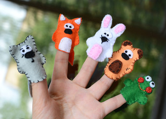 Hand wearing 5 finger puppets; wolf, fox, rabbit, bear, frog
