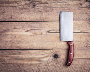 Old butcher knife, on wooden background. Kitchen, cooking.