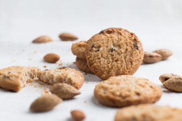 Cookies pile with chocolate chip and almond on light textile background. Delicious morning snacks for breakfast, brunch and lunch. Appetizing, healthy and fast food