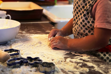 Closeup photo of child hands making  dough for cookies