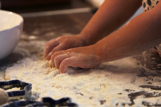 Closeup photo of child hands making  dough for cookies