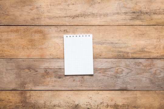 Blank notebook on wooden background.