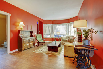 Old country English living room interior with red walls, hardwoo
