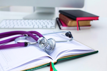 Stethoscope lying on a table on an open book
