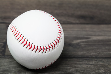 Baseball equipment: ball on a wood plank or bench background