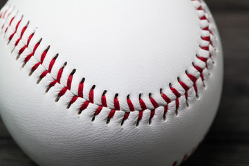 Baseball equipment: ball on a wood plank or bench background