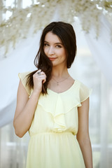 pretty young fashion model posing in light dress in garden house