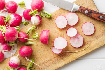 Obraz na płótnie Canvas Fresh radishes on old cutting board.