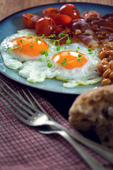 English breakfast with eggs, tomatoes, mushrooms, bacon, beans 