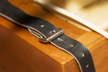 old Genuine leather strap on wood background