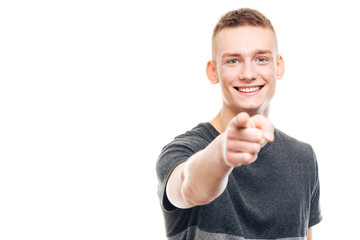 Smiling young man pointing finger at camera