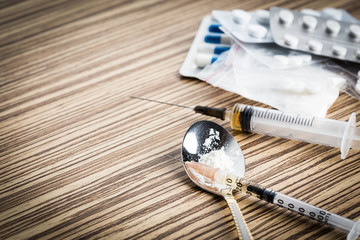 Drug syringe and cooked heroin on spoon