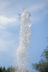 Naklejka na ściany i meble fountain splash water on a background of blue sky 