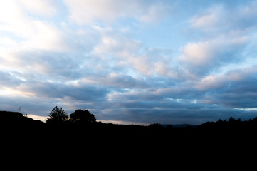 Silueta montañosa con cielo azul nuboso