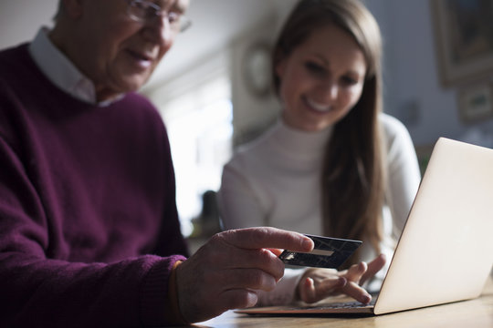 Granddaughter Helping Grandfather To Make On Line Purchase