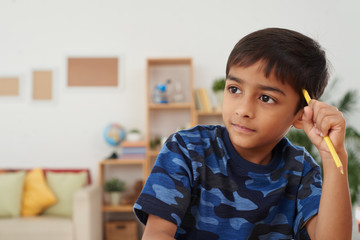 Portrait of cute Indian boy thinking over ideas