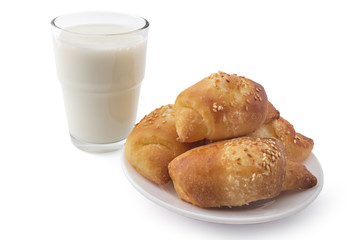 Fresh Serbian pastry rolls with cheese and sesame, on white plate with glass of yogurt, kifla kiflice, isolated on white background
