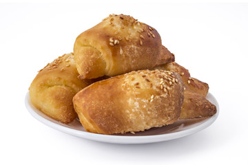 Fresh Serbian pastry rolls with cheese and sesame, kifla kiflice, on white plate, isolated on white background