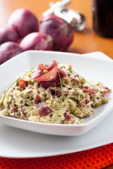 Risotto con bresaola e piselli nel piatto di ceramica bianca sulla tavola apparecchiata