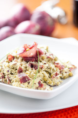 Risotto con bresaola e piselli nel piatto di ceramica bianca sulla tavola apparecchiata