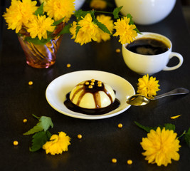 Panacotta - delicious italian dessert with yellow flowers on dark background
