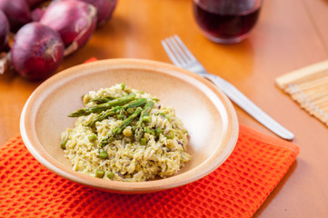 Risotto con asparagi nel piatto sulla tavola apparecchiata