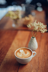 cup of coffee latte art on the wooden desk