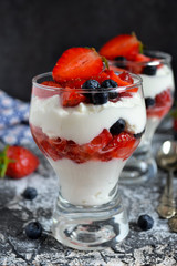 dessert with whipped cream, strawberries, blueberries in a glass