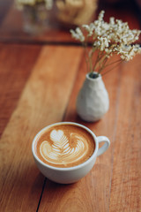 cup of coffee latte art on the wooden desk