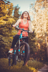 Plakat woman cyclist rides in the forest on a mountain bike.
