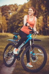 Obraz na płótnie Canvas woman cyclist rides in the forest on a mountain bike.