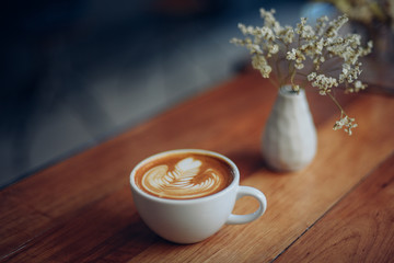 cup of coffee latte art on the wooden desk