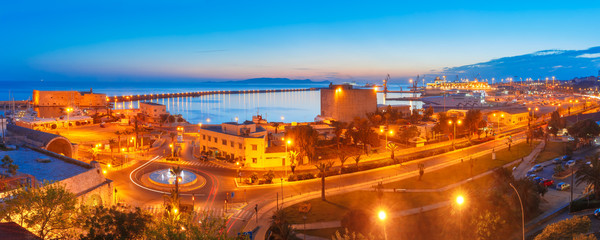 Aerial panoramic view of old harbour of Heraklion with Venetian Koules Fortress and marina during blue hour after sunset, Crete, Greece.