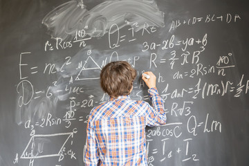Boy writting on black board