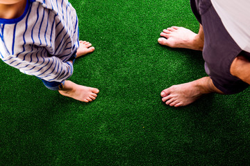 Unrecognizable father and son standing, against artificial green