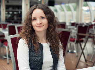 pretty girl with curly hair in cafe