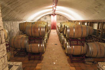 winery, barrels, bottles and glasses of wine