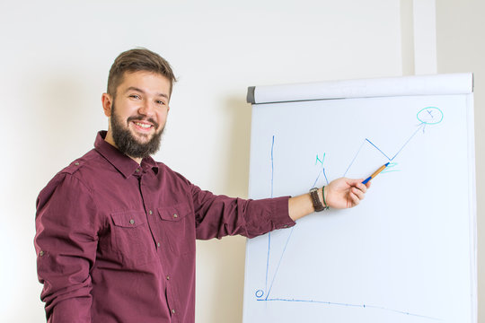 Bearded Man Presenting By The Flipchart