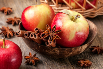 Apples with spices on a wooden background