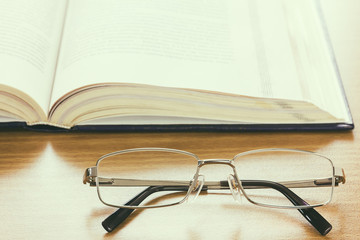 Close up glasses and a book on the desk , vintage style