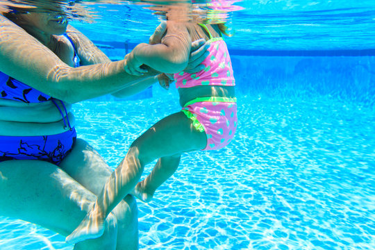 grandmother teaching granddaughter to swim