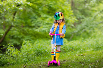 Little girl riding a colorful scooter