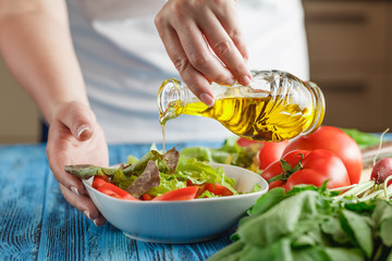 Preparing light vegetarian salad with lettuce, tomatoes and cucu