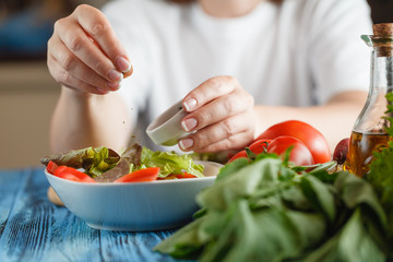 Closeup on woman adding fresh dill into salad
