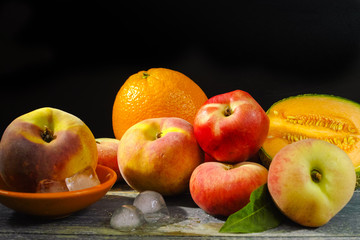 Fototapeta na wymiar Fresh peaches, melon and orange on ice, hot summer concept