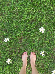 feet on grass,flowers around