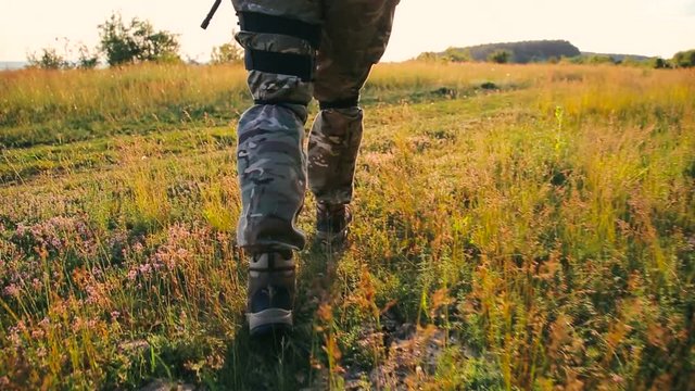 Military foot goes on the grass