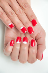 red manicure with white inserts on tanned hands
