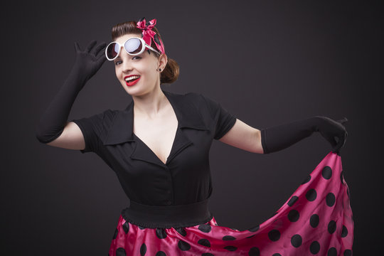 Happy smiling young woman with pin-up make-up and hairstyle posi